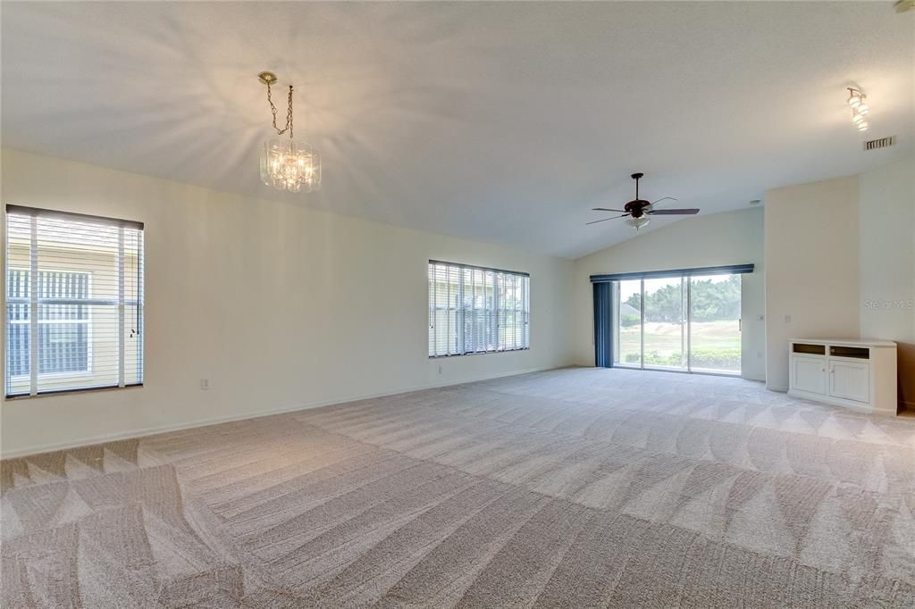 Living Room leads to screened in porch overlooking driving range