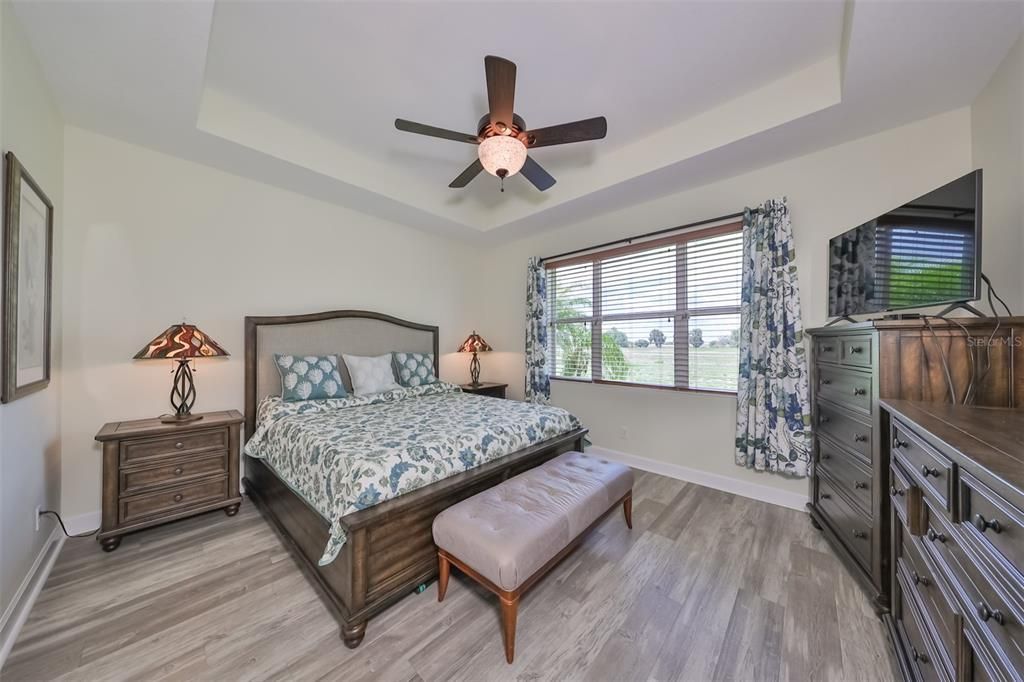 Owner's suite boasts beautiful engineered flooring, tray ceiling and custom ceiling fan.
