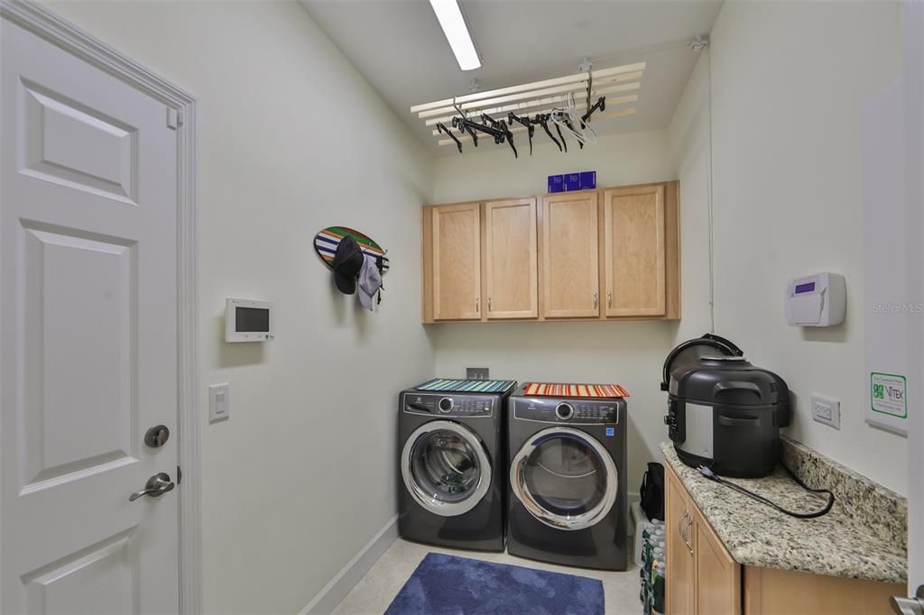 A large laundry room with Electrolux washer and dryer and a hanging rack (which drops down from the ceiling) makes the task of doing the laundry much more enjoyable!