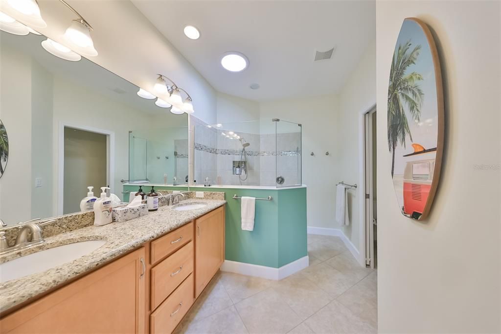 Owner's ensuite bathroom has granite counters, matching cabinetry, dual sinks, high end shower head and a solar tube.