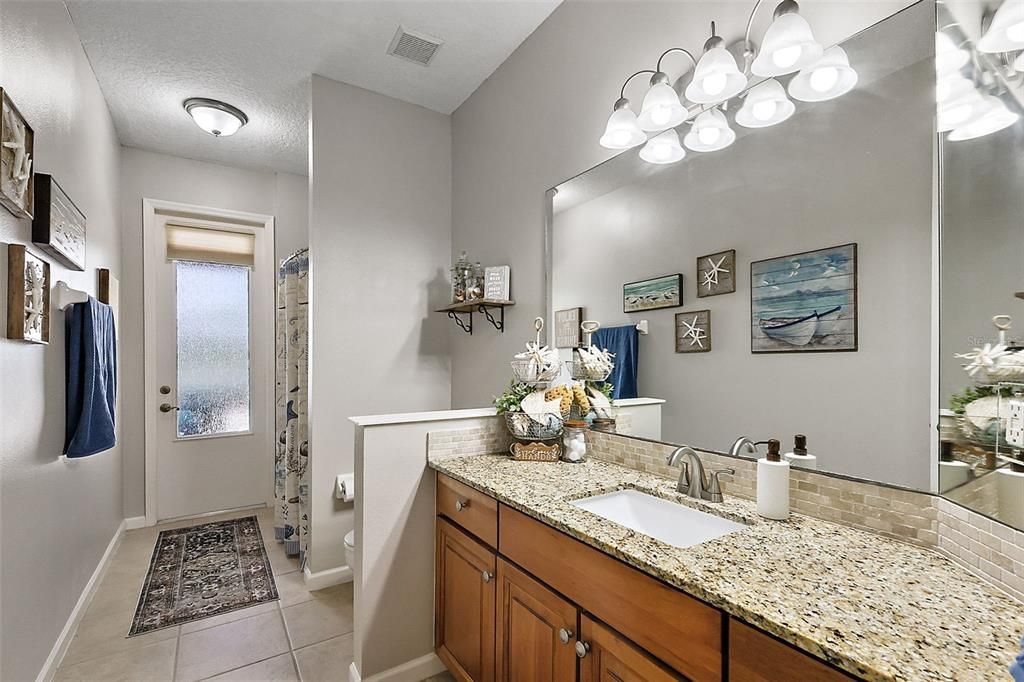 Hall/guest bath with Granite and door to the pool.