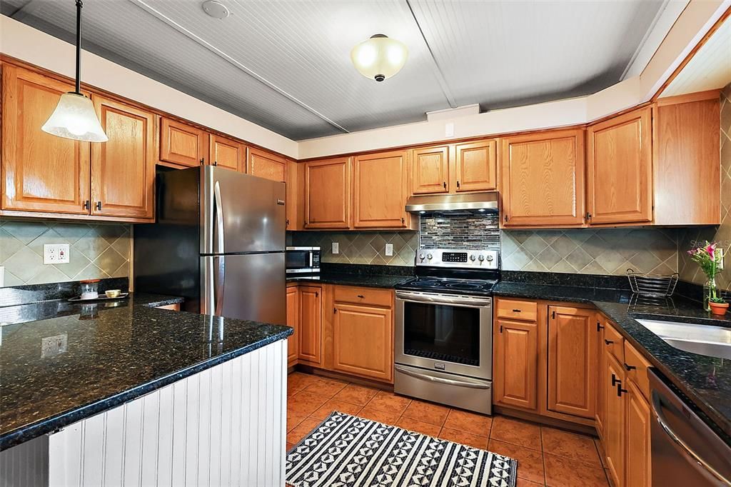 Well-appointed kitchen with Granite, breakfast bar, ss appliances and wood cabinetry