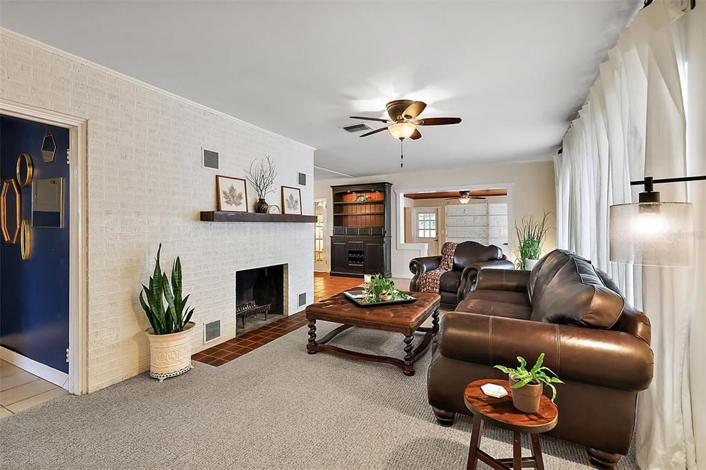 Beautiful living area, with wood burning fireplace and artsy brick wall