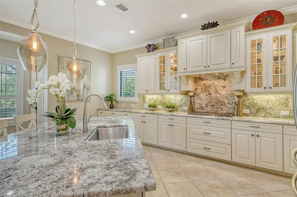 Beautiful light cabinetry and stone countertops and backsplash