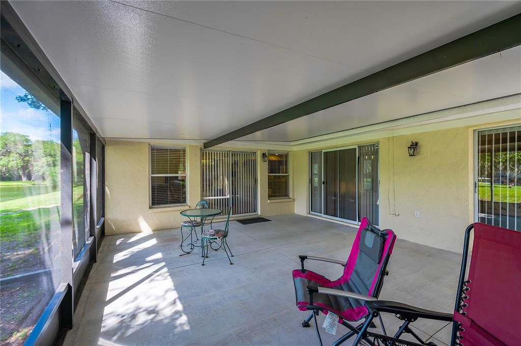 Screened lanai with three sets of double sliding doors into the living room, family room and primary bedroom