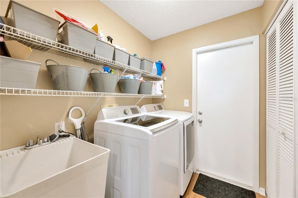 Laundry room with laundry sink, good shelving space and storage closet