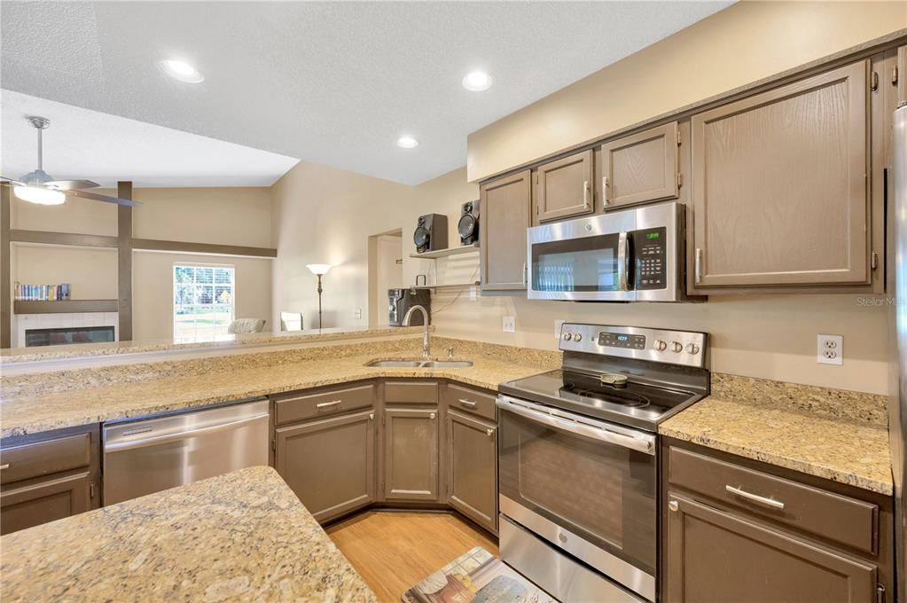 All appliances stay in the eat-in kitchen with island, stainless steel appliances, coffee bar/built in desk, laminate floors and granite countertops.  Lovely breakfast bar in addition to the eat-in area that will accommodate a breakfast table
