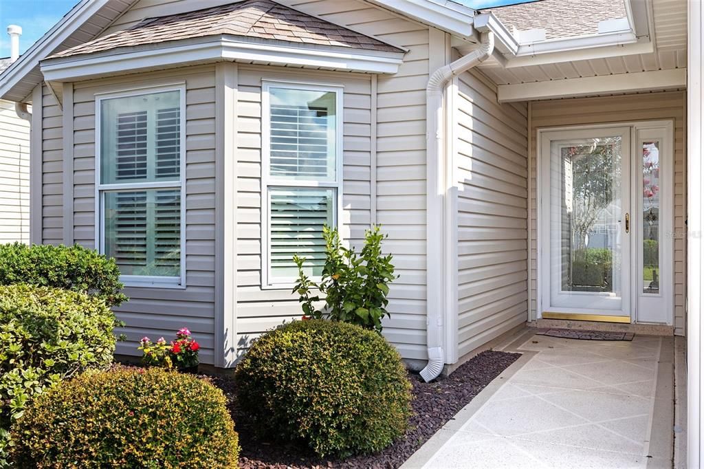 Step through the decorative glass front door including matching sidelite and storm door