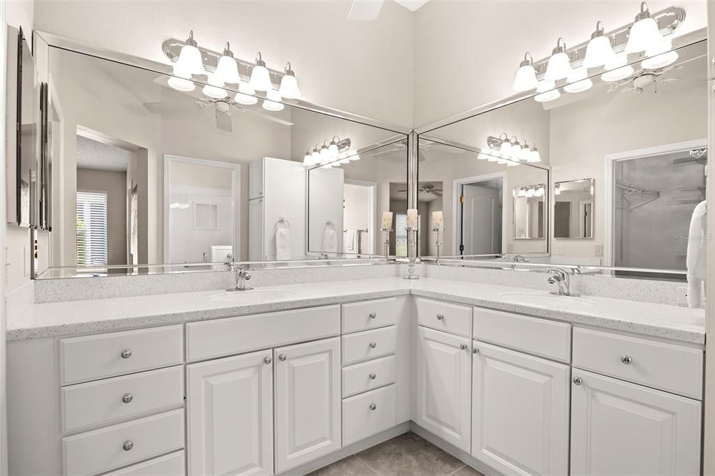 This luxurious bathroom is equipped with dual sinks, white cabinets, custom raised bathroom vanity with new countertop and plumbing fixtures.