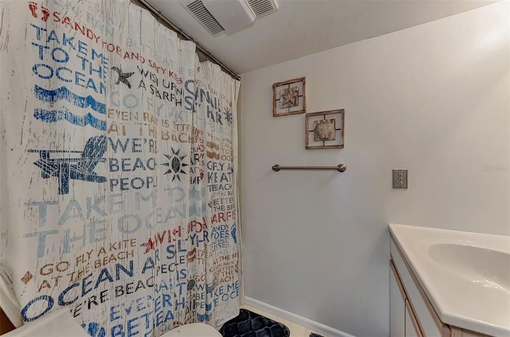 Full tub/shower behind the shower curtain.