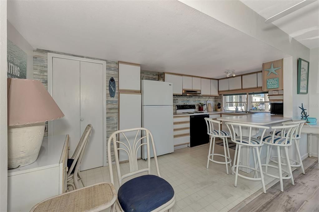 On the left where the single chair is located is the dining area.  Current owner puts his desk there instead.  Note the breakfast bar with4 chairs.