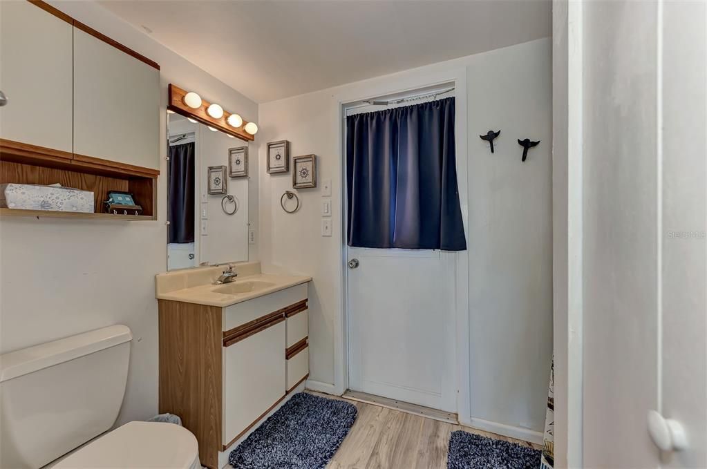 Bathroom  2 with an exit door through to the back of the home.  The shower is to the right.