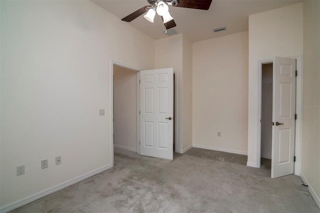 The second bedroom has 2 closets, ceiling fan with light, and custom carpeting. The niche is perfect for a computer desk.