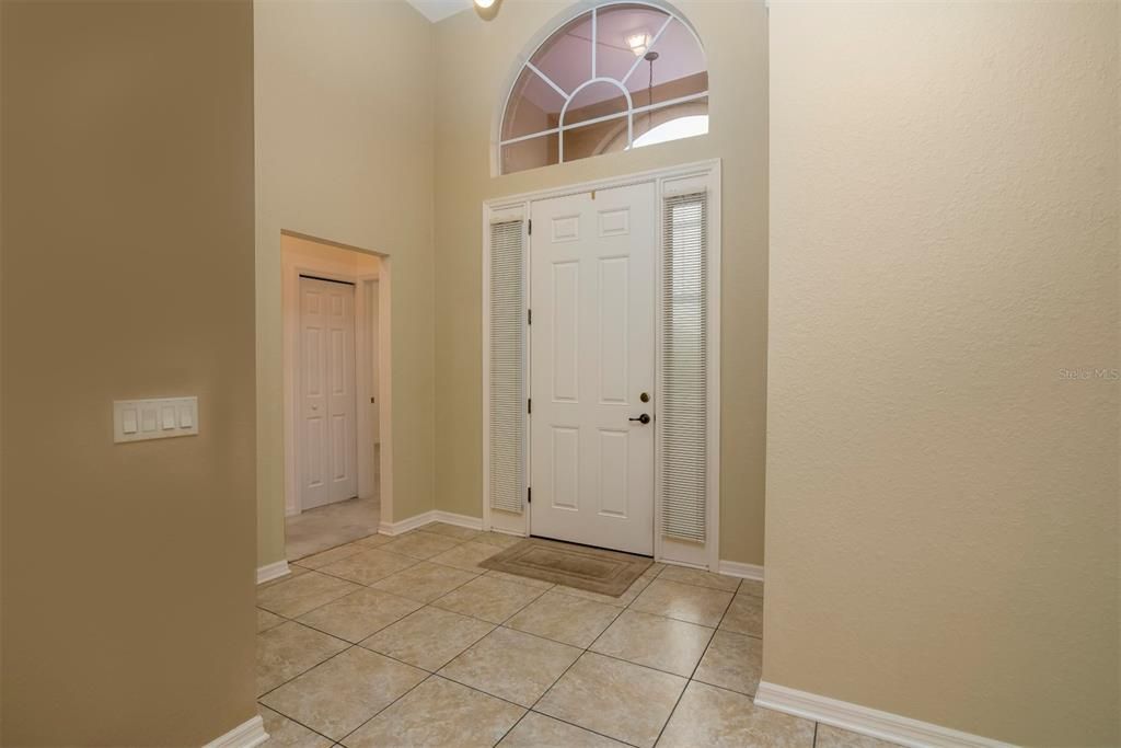 The vaulted foyer gets great natural light from the over the transom window and sidelights. The opening to the guest wing is on the left.