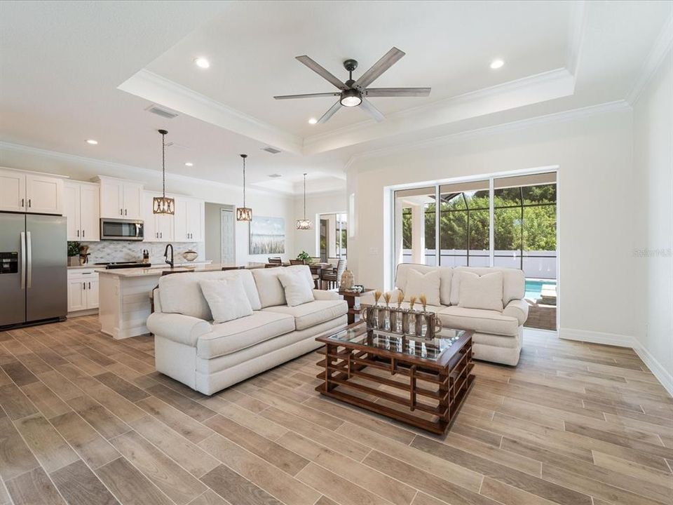 Great room with tray ceiling and sliding pocket glass door