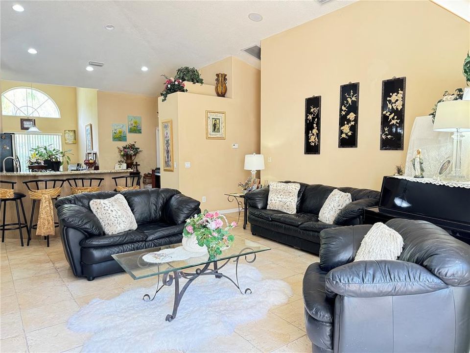 Family room with gas fireplace, built-in entertainment system, surround sound, triple sliding glass door leading to the pool and spa area, view of high breakfast bar