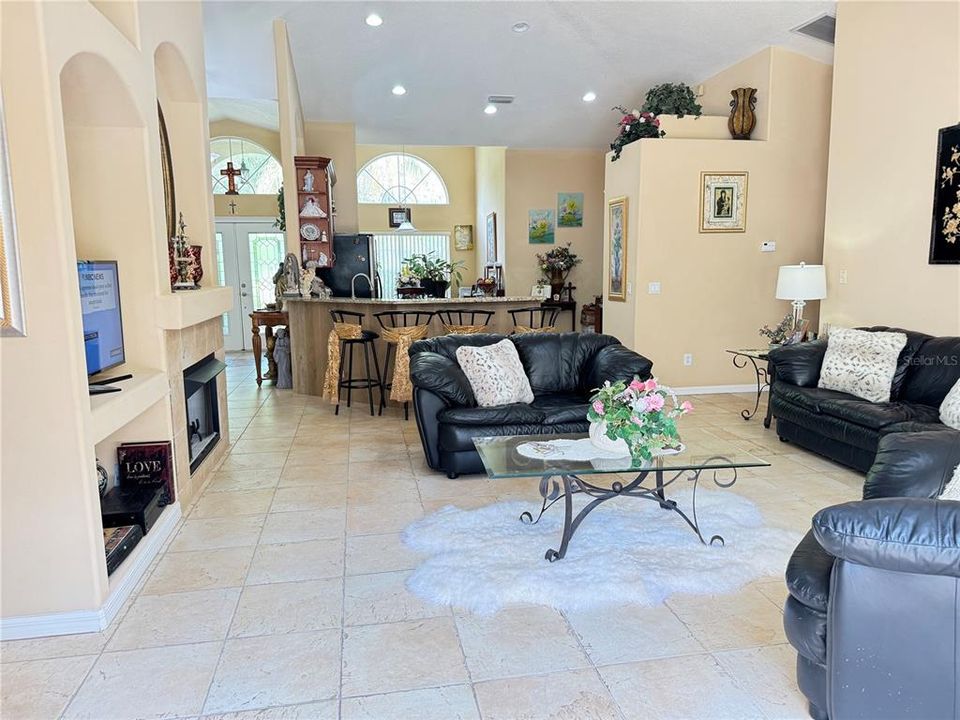 View of stairs leading to bonus room/bedroom, wooden handrail and spindles in upper lever, gas burning fireplace, art niches