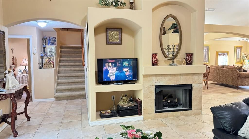 Family room with gas fireplace, built-in entertainment system, surround sound, triple sliding glass door leading to the pool and spa area, view of high breakfast bar