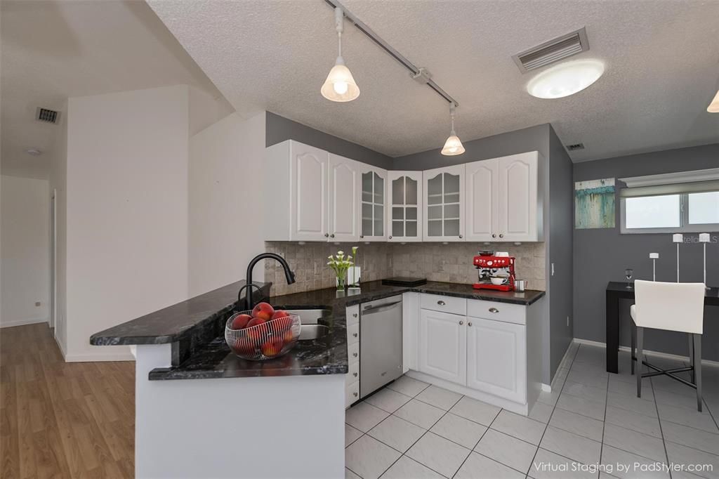 Stately kitchen with breakfast bar and informal dining nook opens to the great room.