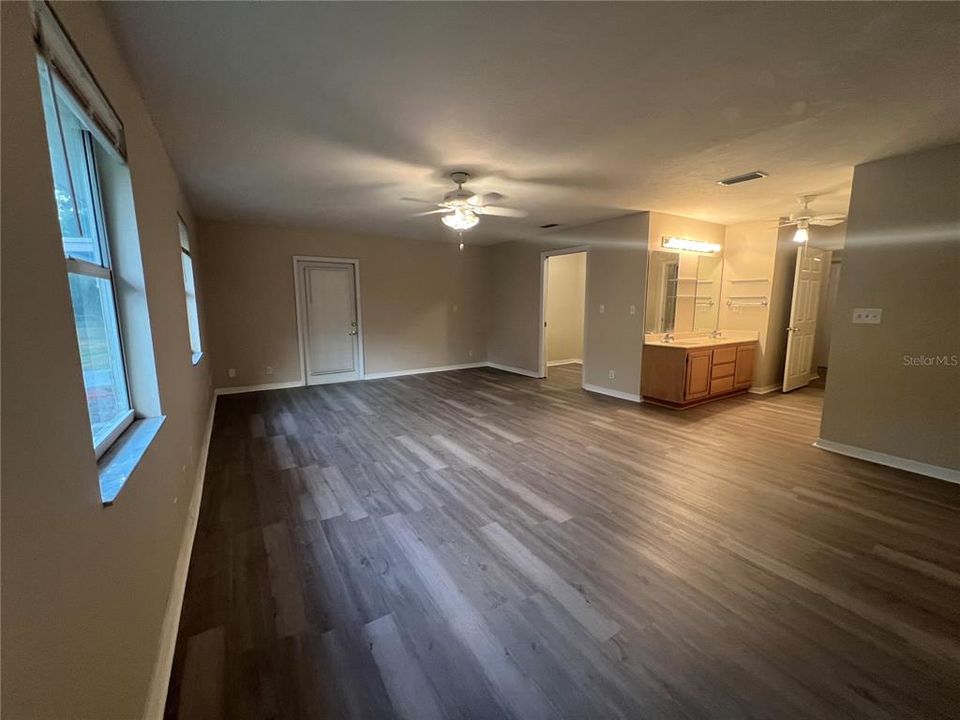 Main bedroom with new LVP flooring throughout and rear exit door to patio