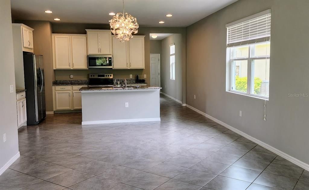 Kitchen with island sink, white cabinetry, stainless appliances