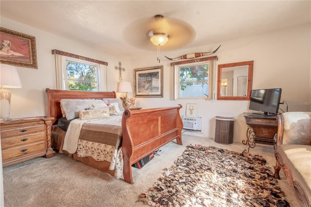 The In-law suite 14 x 16 with private entrance features plush carpeting, a dedicated A/C unit, a built-in closet, a ceiling fan with light kit and an ensuite full bath.