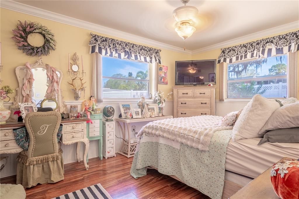 Primary bedroom features wood laminate flooring, built-in closet, and a ceiling fan with light kit.