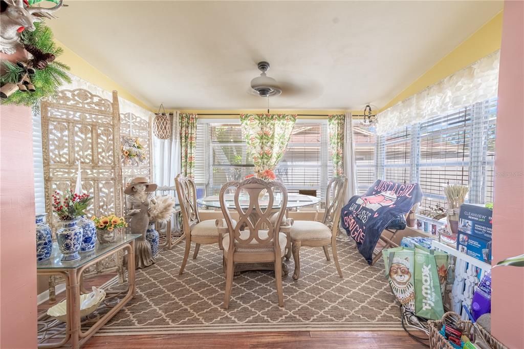 The Florida room is light and bright with wall to wall windows, wood laminate flooring and a ceiling fan.