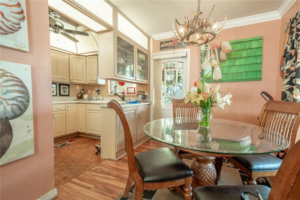 A decorative chandelier hangs above the kitchen table.