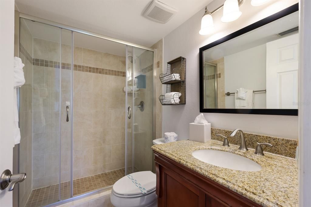 second bathroom with granite countertops and stand up shower