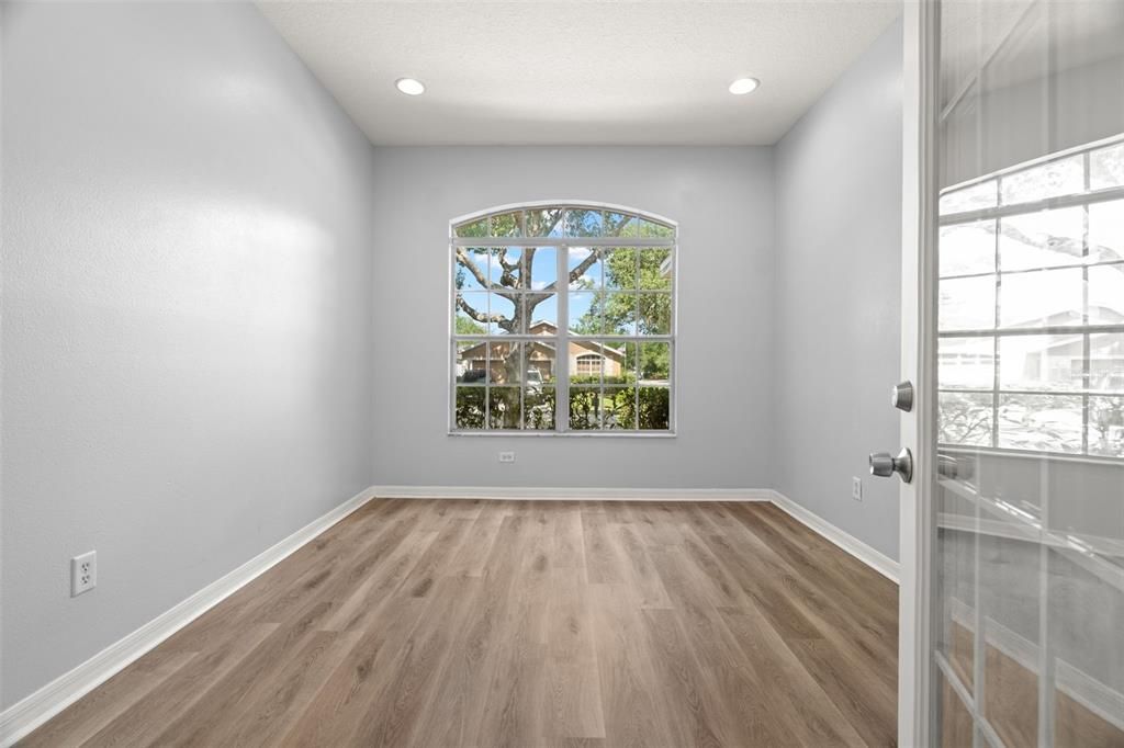 Home office/den - inside the front entrance.  Recessed lighting and a large window with view of mature trees would be a great place to work at home!