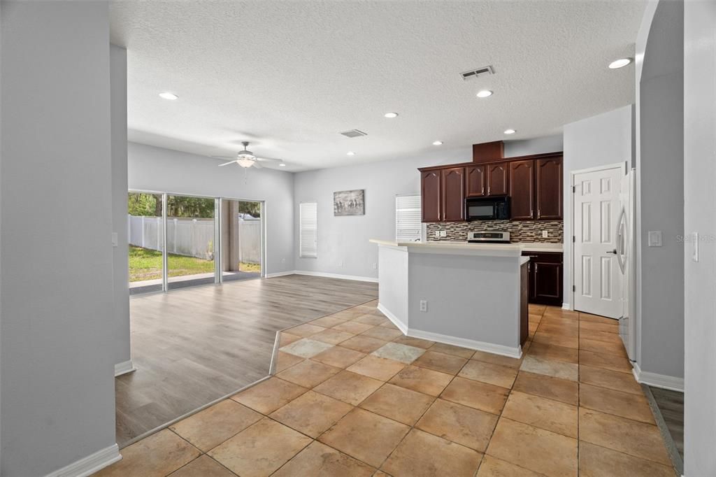 View of kitchen from dining space.  Ceramic tile is where it counts for easy care in the eating and cooking space.