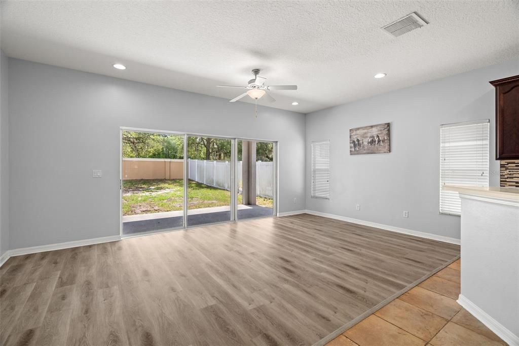 Living room space has recessed lighting, ceiling fan/light and easy care laminate flooring.