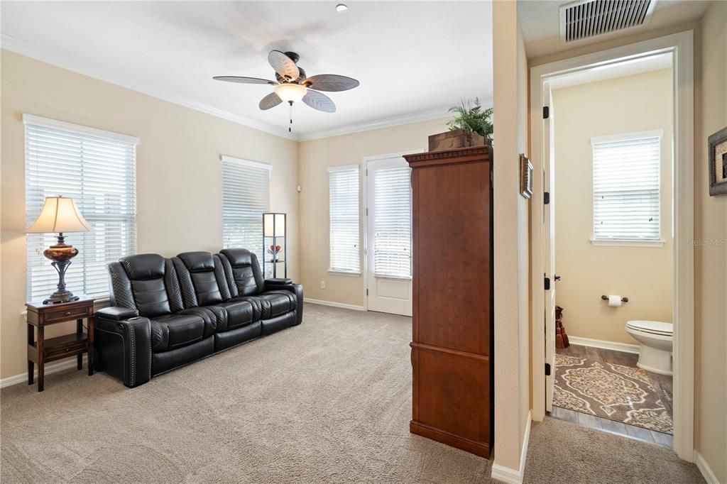 Spacious family room is light  and bright with multiple windows, door to balcony and  crown moulding