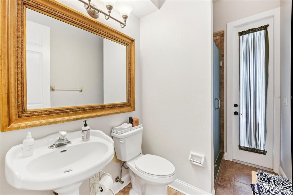 Full bathroom with walk-in shower near office with a door leading out to the pool and lanai