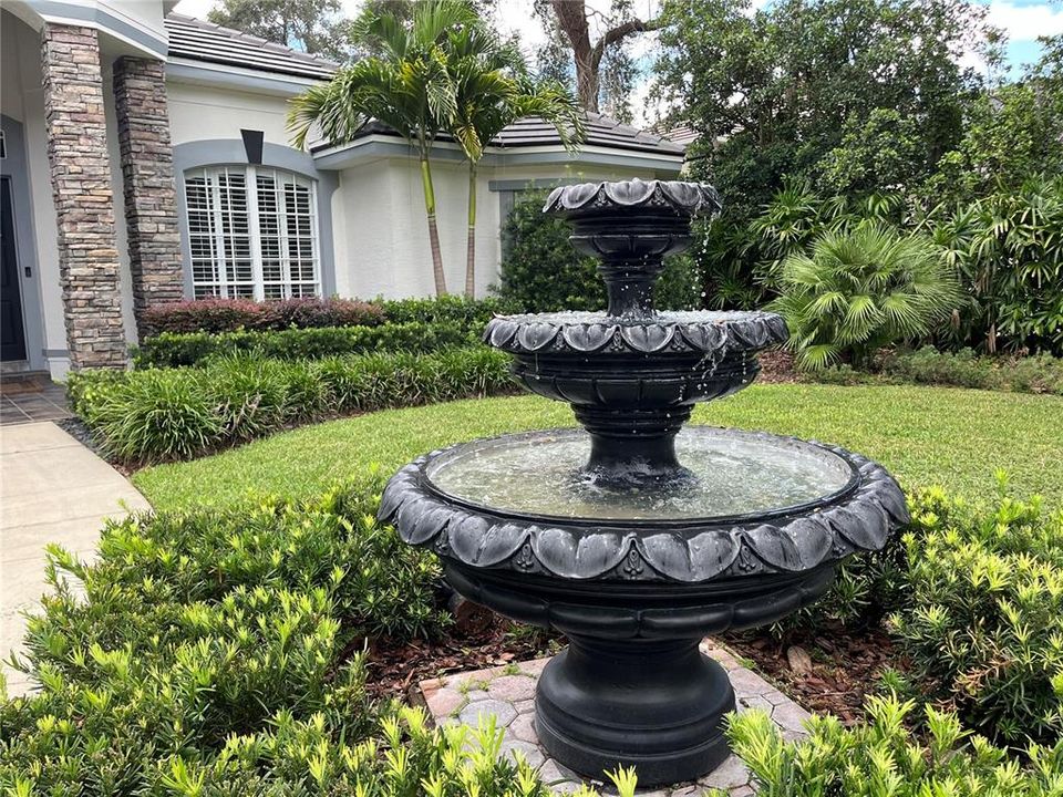 Quaint fountain along the walkway to the entrance of the home