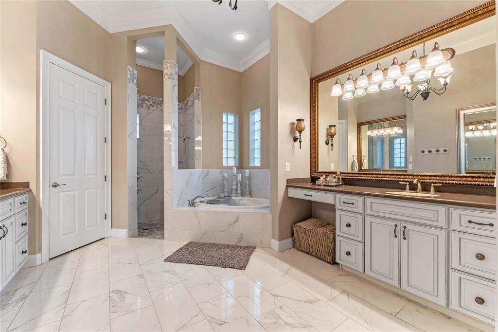 The luxurious primary bathroom features a spacious layout with dual vanities, a large soaking tub, a walk-in shower, and elegant marble finishes throughout.