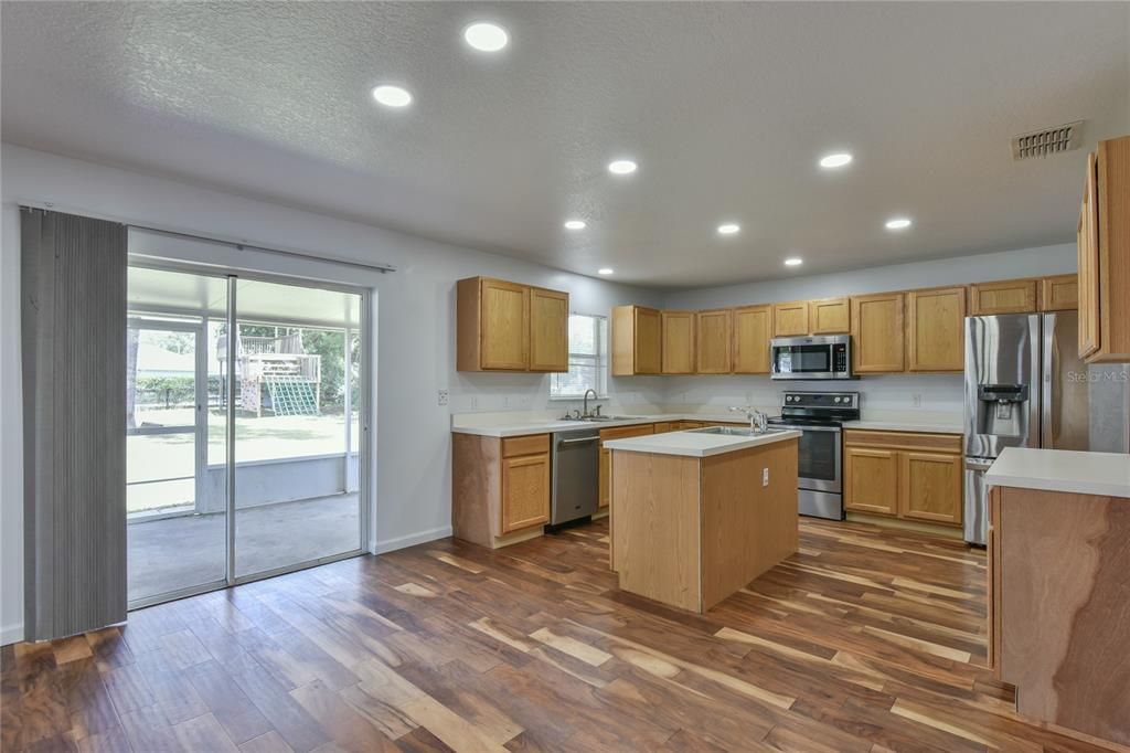 The Kitchen has wood cabinets and sliding glass patio doors