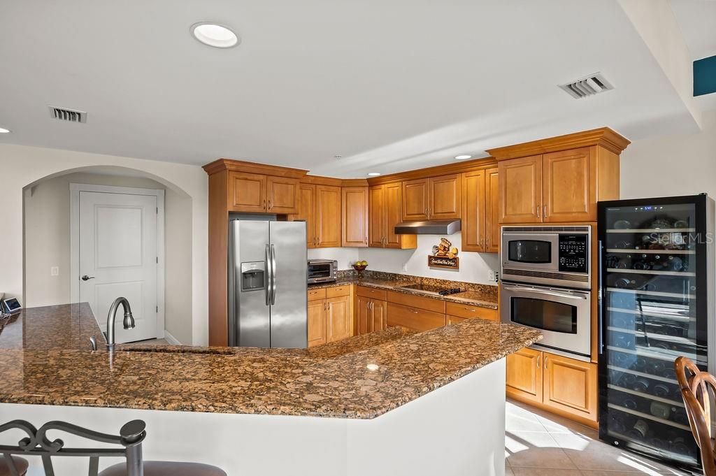 Large chefs kitchen with walk in pantry and stainless steel appliances.