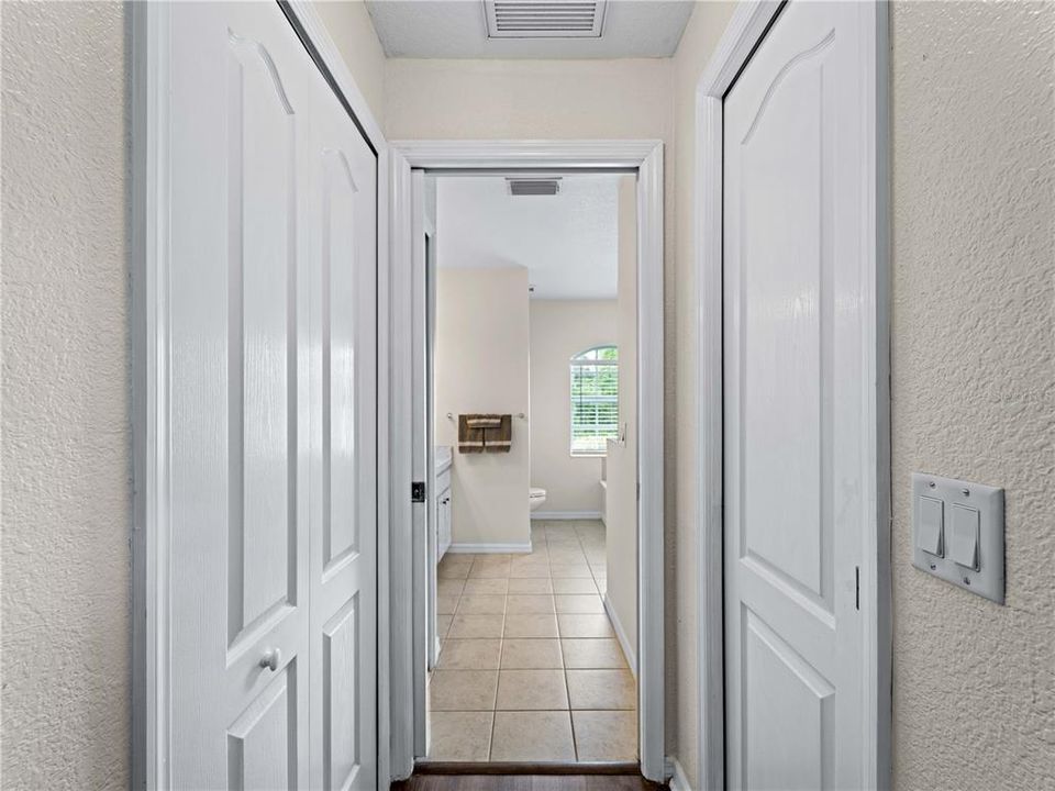 Dual closets down hall to primary bathroom