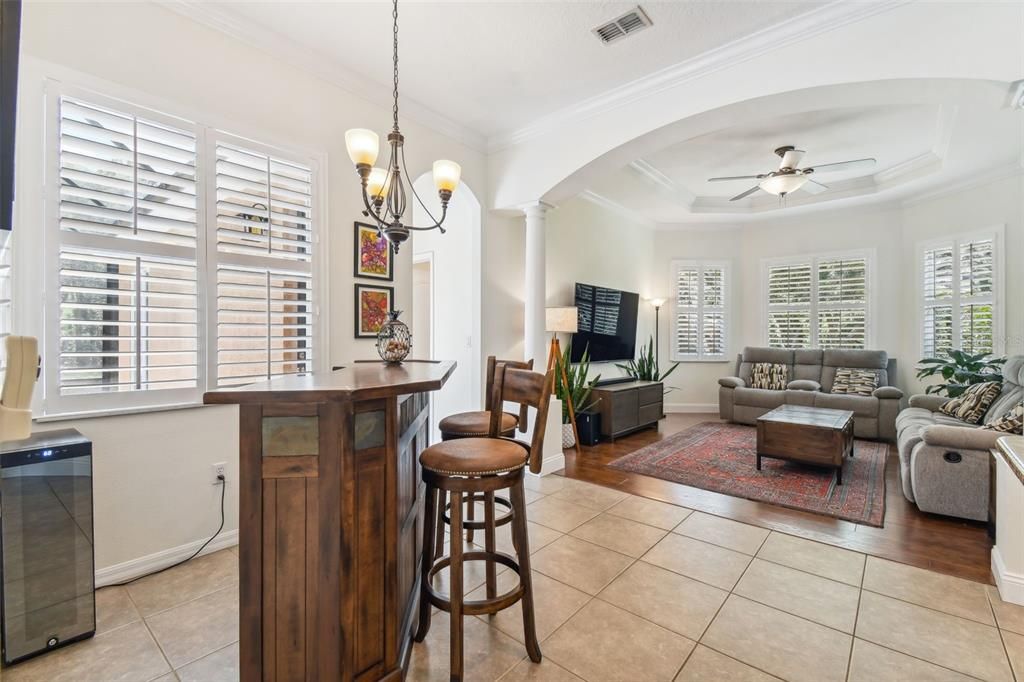 Bar/living room area just to the left of the kitchen with plantation shutters covering the windows.