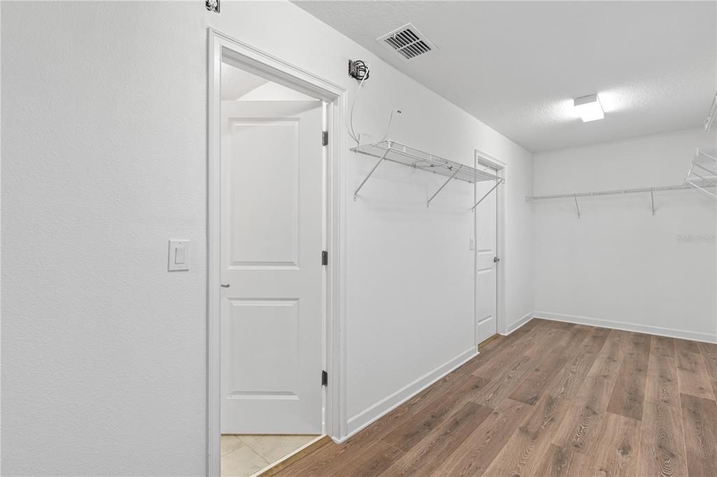 huge walk-in closet with access to the laundry room