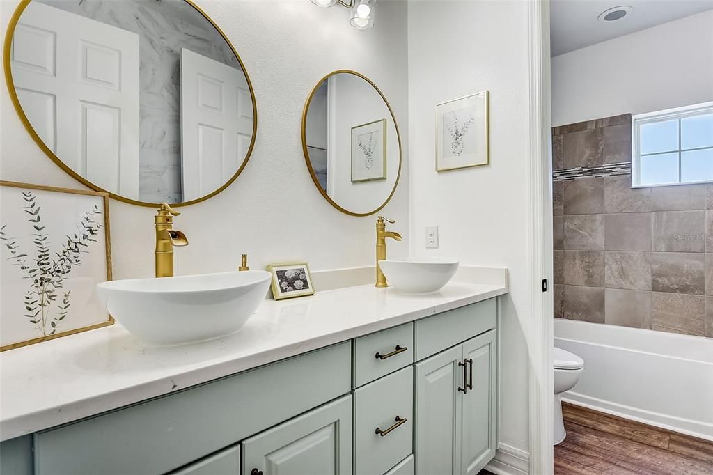 Bath 5 second floor upgraded vanity-quartz countertops and brass toned fittings overhanging single bowls