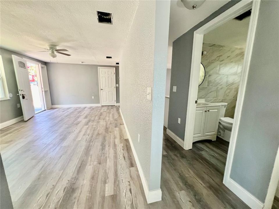 VIEW OF LIVING ROOM AND BATHROOM FROM HALLWAY