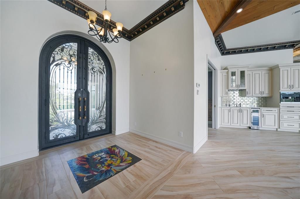 The foyer with inlaid tile and incredible custom doors.