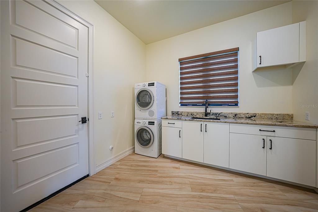 Laundry room with high-quality appliances and stone countertops -- and a window!