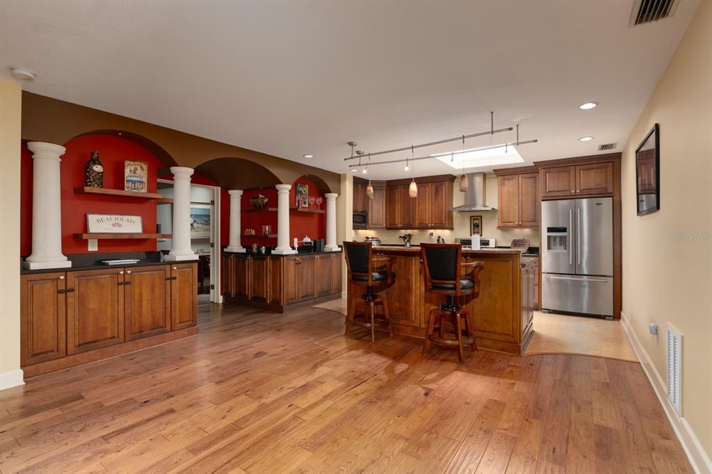 Kitchen with island bar. Primary bedroom access to the left.