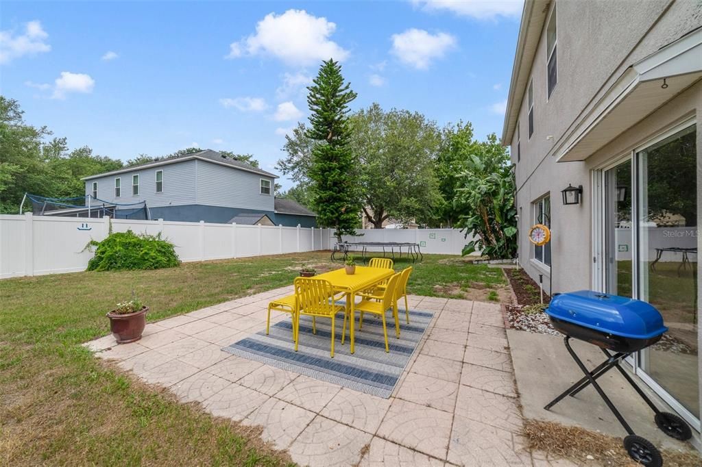 Large paver patio with view of fenced yard