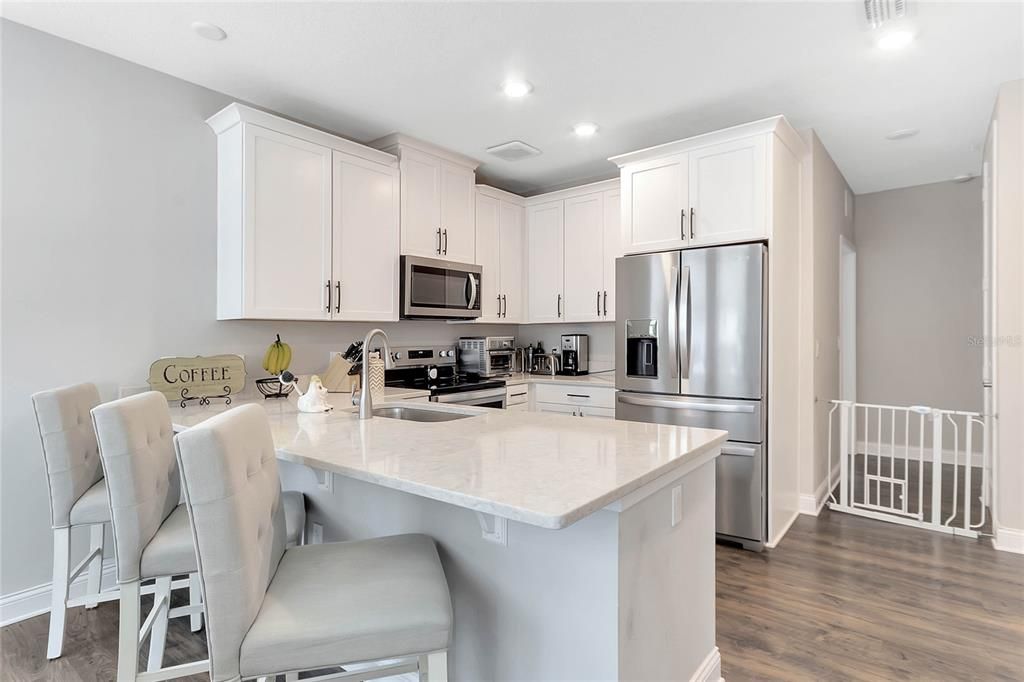 The beautiful kitchen is at the heart of this home and offers shaker style cabinets topped with crown molding, STAINLESS STEEL APPLIANCES (including an UPGRADED REFRIGERATOR!), stone counters, recessed lighting and more seating at the breakfast bar!