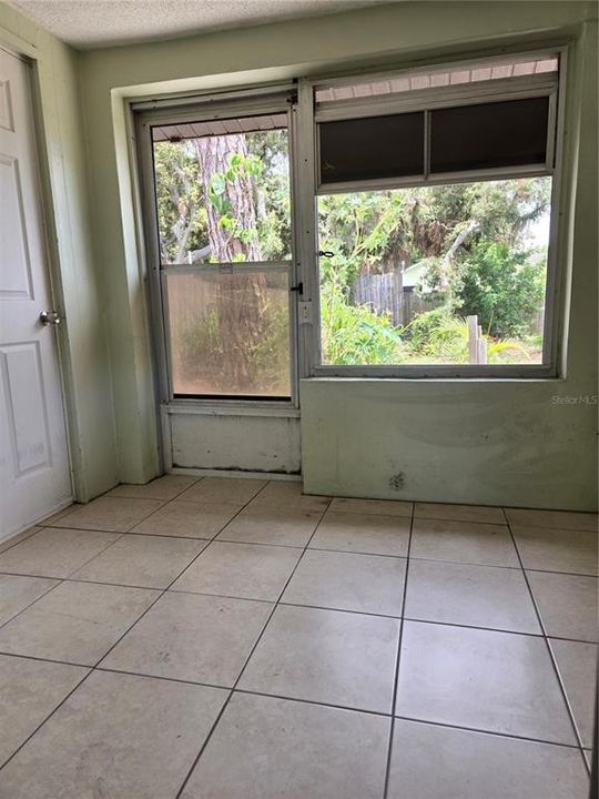 entrance on side yard into screened foyer area